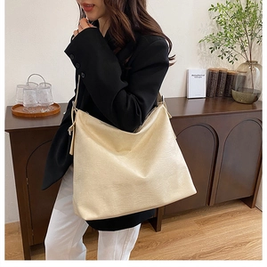 Close-up of beige leather tote bag featuring rich texture and spacious hobo design