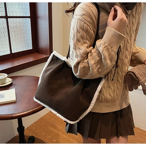 Close-up of deep brown suede tote bag with white faux shearling trim on shoulder