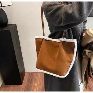 Detail of suede and faux shearling trim on large brown autumn shoulder tote bag