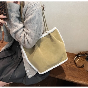 Detail of mustard suede shoulder bag with white faux shearling trim and long leather strap