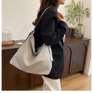 Close-up of off-white large tote bag with soft leather texture on a female model