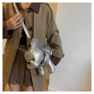 Detail shot of a silver French Bulldog shaped crossbody bag worn by a model