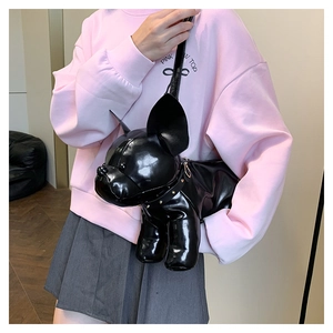 Detail of a shiny black French Bulldog shaped crossbody bag with gold rivet accents
