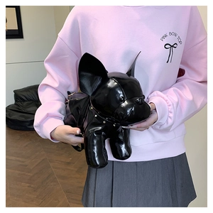 Detail of dog-shaped crossbody bag in glossy faux leather with studded collar and metal strap