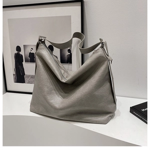 Detail view of grey litchi grain leather hobo bag with a secure metal zipper closure