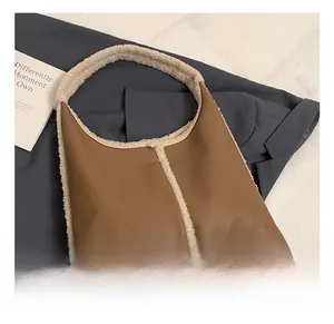 Detail of caramel faux leather shoulder bag with white fleece trim and lychee texture