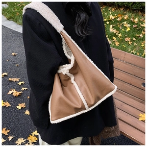 Detail view of caramel brown pebbled leather tote with plush white faux shearling trim