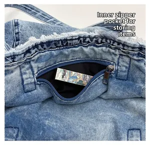 Detail view of denim tote bag showing interior zipper pocket and washed fabric texture