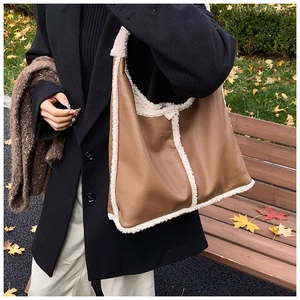 Detail of the brown pebble leather tote bag with thick cream shearling trim detail