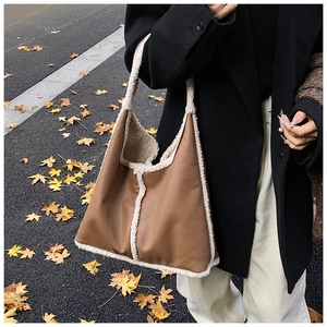 Detail view of a vintage large capacity hobo bag with brown leather and plush shearling trim