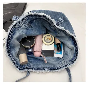 Macro view of the large capacity interior with zipper pocket in washed denim tote bag