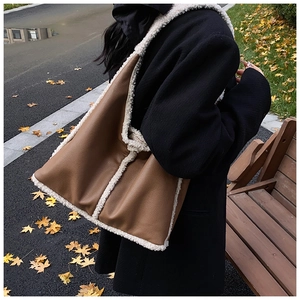 Close-up of retro bucket bag featuring brown pebbled leather and white faux fur trim