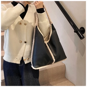 Detail of contrast stitching faux shearling trim on large black leather tote bag