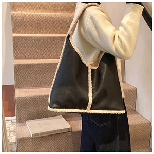Detail of the oversized tote bag with black lychee leather and beige faux fur trim