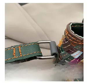 Détail d'un sac en cuir tressé coloré avec anneau en D argenté et surpiqûres précises