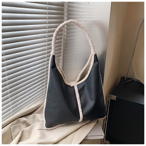 Detail of the high-capacity hobo bag featuring black lychee leather and beige shearling trim