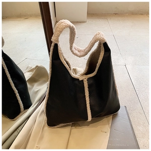 Detail view of black pebbled leather hobo bag with cream sherpa trim and fuzzy handle