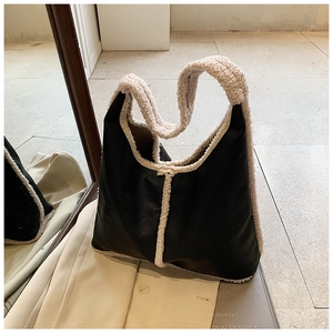 Detail of black PU leather tote with plush faux shearling trim and spacious interior