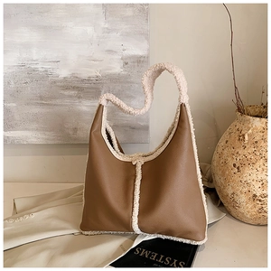 Detail showing brown leather hobo bag with thick faux shearling trim and handle detail