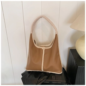 Detail of faux leather and shearling dumpling bag in brown and cream contrast