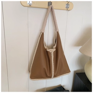 Close-up of brown faux leather tote with cream fleece trim on a wooden wall hook
