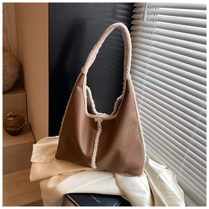 Detail of brown faux leather tote bag with white faux fur trim on a white shirt background