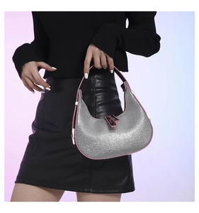 Macro shot of silver sequin hobo bag with pink trim and elegant metal buckle detail