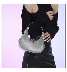 Close-up of sparkling silver rhinestone crescent shoulder bag with adjustable strap