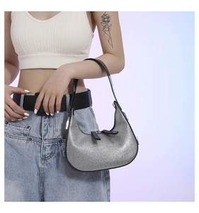 Detail of silver glitter crescent hobo bag with sleek black shoulder strap and sequins