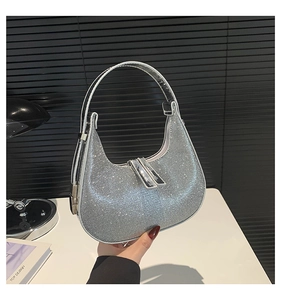 Detail of silver rhinestone crescent hobo bag featuring premium crystal texture and top handle