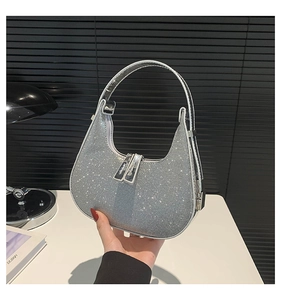 Macro detail of silver sequin hobo bag with glitter texture and metal zippers
