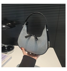 Close-up of sparkling silver rhinestone hobo bag with sleek black leather handle