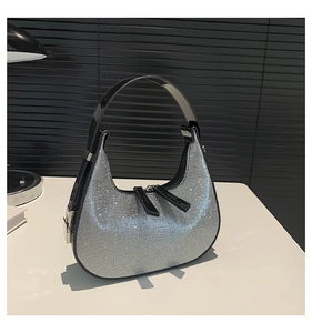 Detail of silver rhinestone hobo bag showing sparkling crystals and black leather handle