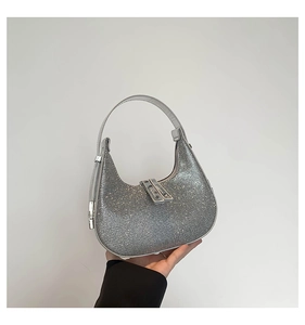 Detail of silver sequined crescent handbag with metallic glitter and dual buckle closure