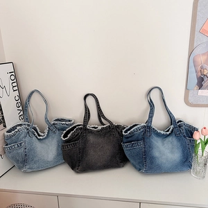 Three denim tote bags with frayed edges and side pockets in various blue shades