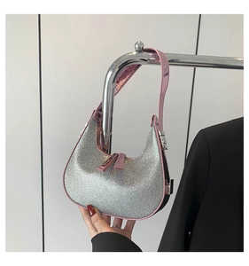 Detail of silver rhinestone hobo bag with pink metallic handle and secure zipper closure