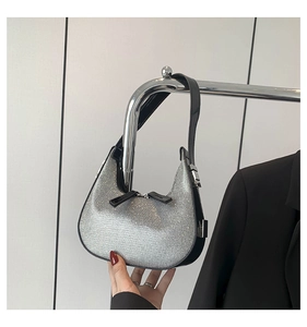 Close-up of sparkling silver rhinestones on the moon-shaped underarm bag with black trim