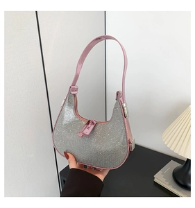 Detailed close-up of a silver rhinestone crescent bag with pink patent leather strap