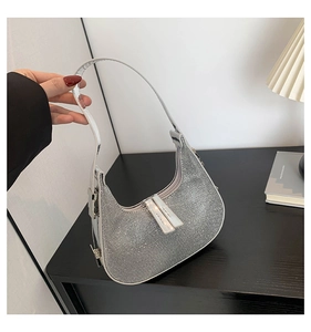 Macro detail of silver rhinestone hobo bag showing sequin zipper pulls and crescent shape