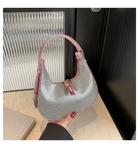 Detail of pink leather trim and sparkling silver rhinestones on a crescent hobo bag