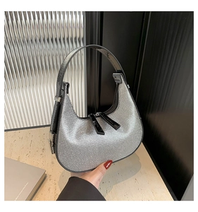 Detail of silver rhinestone hobo bag showing sparkling crystals and black leather strap
