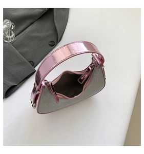Macro view of silver glitter crescent bag featuring pink metallic mirror finish handle detail