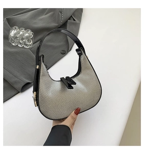 Detailed top view of a silver rhinestone hobo bag with sleek black handles and metal buckles