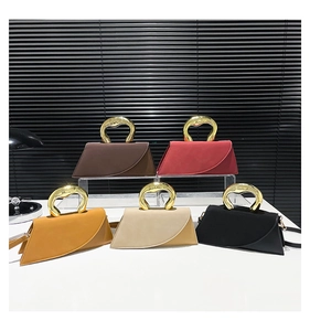 Detail showing various colors of modern trapezoid handbags with gold arc metal handles
