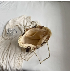 Top view of woven straw tote bag showing interior lining with pockets and zipper closure