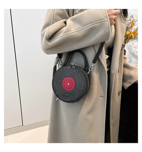 Unique vinyl record-shaped crossbody bag with embossed portrait and silver cone rivets