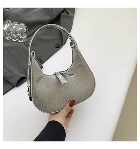 Macro detail of a silver rhinestone crescent moon hobo bag with sparkling crystal strap