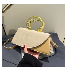 Detail of contrast-panel beige and yellow square handbag with sculptural gold handle