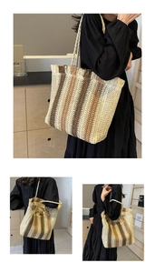 Detail of a large woven straw tote bag featuring tassel edges and gradient stripe design