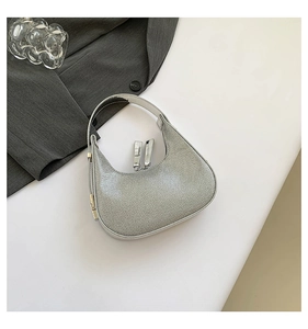 Close-up of a silver hobo bag with rhinestone mesh finish and dual zippers on white surface